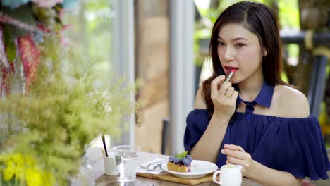 Frau-Make-up-mit-Lippenstift-in-einem-Café-zu-tun