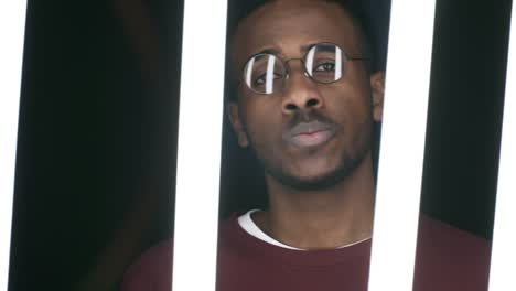 Defiant-Black-Man-Posing-behind-Fluorescent-Tubes