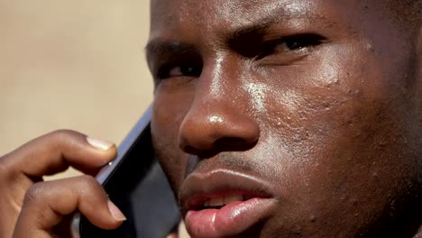 close-up-on-Youn-black-business-african-man-talking-by-phone--outdoor