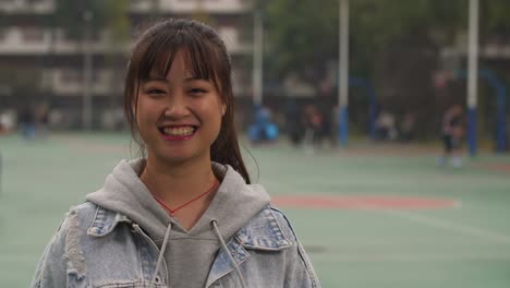 Portrait-of-young-asian-girl-smile-at-camera-in-campus