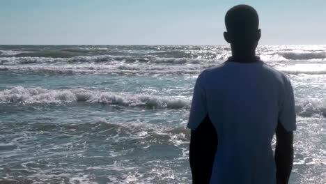 African-man-alone-contemplating-the-sea.-Migration,sea,-help