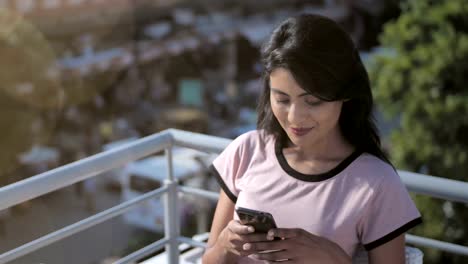 Eine-attraktive-und-glückliches-Mädchen-lächelt,-sucht-das-Handy