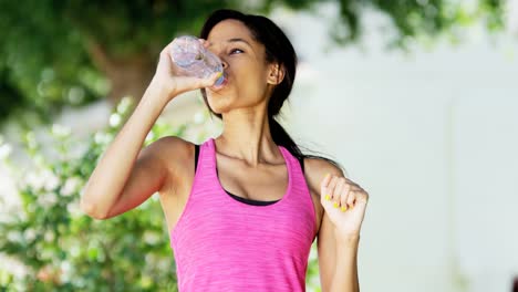 Portrait-ethnic-girl-drinking-water-wearing-workout-clothes