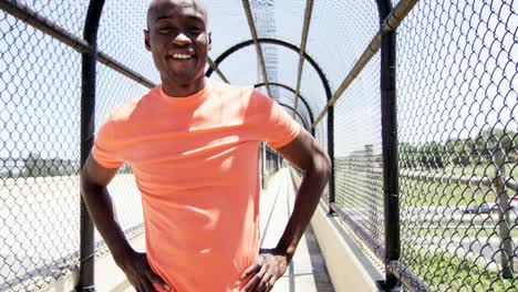 Young-active-ethnic-male-stretching-on-walkway-outdoors