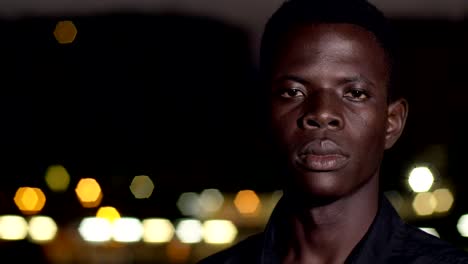 Proud-serious-young-african-black-man-staring-at-camera-in-the-night