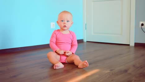 Happy-little-girl-sitting-on-the-floor-of-the-house.-Happy-childhood