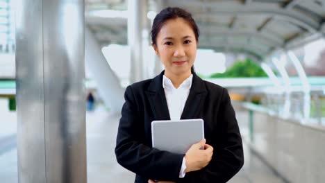 Young-businesswoman-walking-straight-ahead-on-modern-bridge