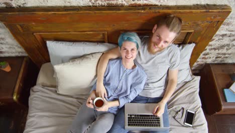 Pareja-Hipster-feliz-sentado-en-la-cama