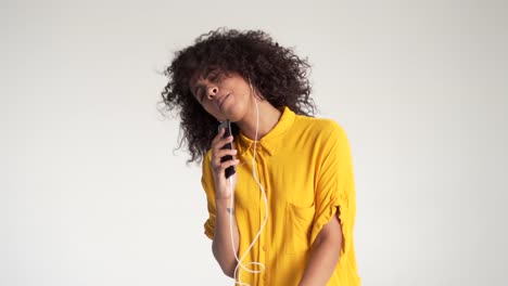 African-american-woman-singing-while-listening-music-on-mobile-phone-app