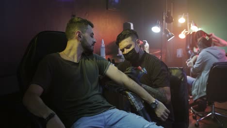 Slow-Motion-Of-Happy-Young-Man-Getting-Tattoo-And-Smiling