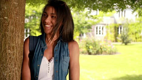 Smiling-student-leaning-against-the-tree