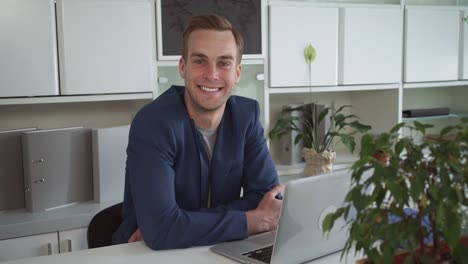 Happy-businessman-working-on-the-laptop-in-the-modern-office