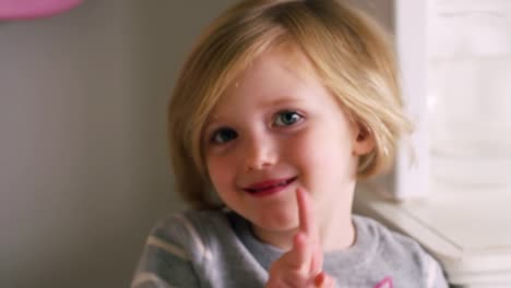 Little-girl-posing-and-making-a-peace-sign-for-the-camera