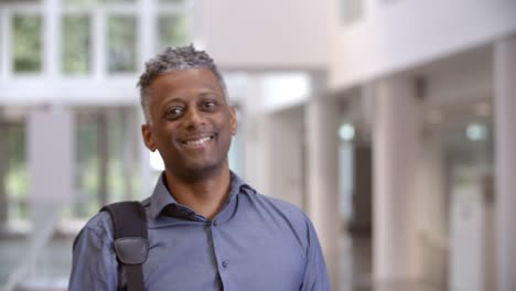 Middle-aged-black-male-teacher-walking-into-focus-in-a-lobby