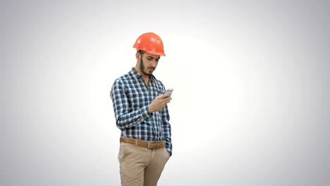 Joven-Gerente-en-casco-usando-teléfono-móvil-sobre-fondo-blanco