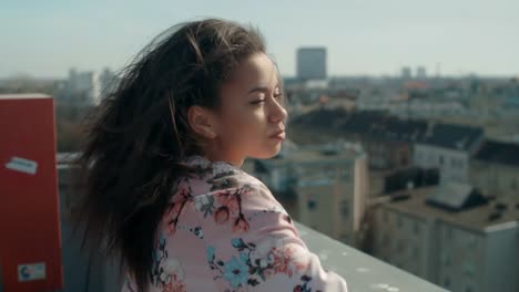 Young-beautiful-woman-enjoying-time-on-a-rooftop.