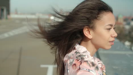 Young-beautiful-woman-enjoying-time-on-a-rooftop.