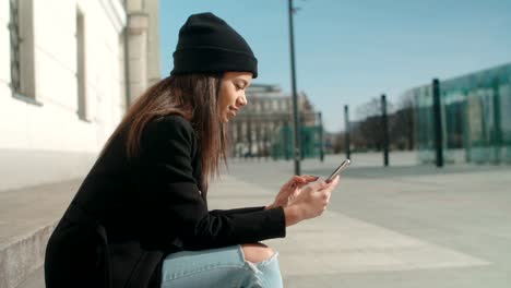 Portrait-of-young-African-American-woman-using-phone,-outdoors.