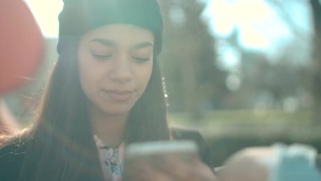 Portrait-of-young-African-American-woman-using-phone,-outdoors.