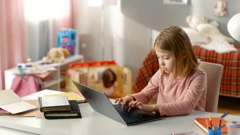 Totale-eine-süße-junge-Mädchen-Tipparbeit-auf-Laptop-sitzend-am-Tisch-in-ihrem-Zimmer.