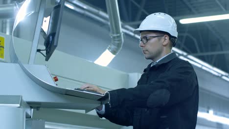 Ingenieur-in-Schutzhelm-Einrichten-von-CNC-Maschine-in-der-Fabrik