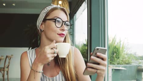 Schöne-junge-Mädchen-SMS-auf-dem-Handy.-Frau-mit-Messanger-auf-Smartphone-im-Café-und-lächelnd.