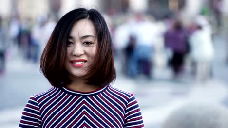 Portrait-of-playful-asian-woman-having-fun-outdoor-on-city-square