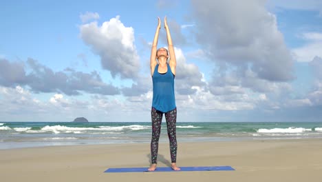 Young-woman-balance-yoga-exercise-on-the-beach-in-front-of-sea.-Healthy-active-lifestyle-concept.