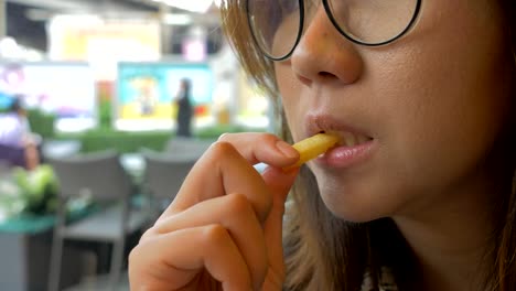 young-woman-eating-french-fries