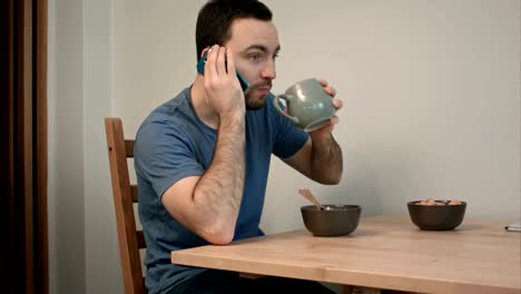 Young-man-having-a-phone-call-over-breakfast