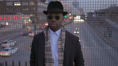 Hombre-joven-con-origen-étnico-afroamericano-con-Look-clásico-antiguo.-Divertirse-en-la-gran-ciudad-con-gafas-de-sol,-sombrero-y-bufanda.