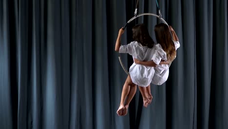 Zwei-Mädchen-schwankt-in-der-aerial-hoop