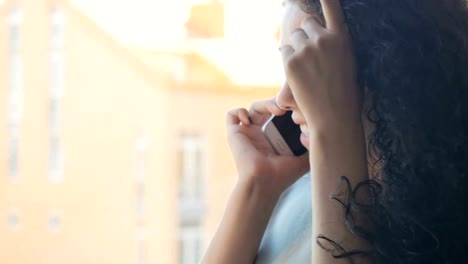 Cute-girl-talking-on-the-phone-with-a-friend-who-is-standing-outside-the-window