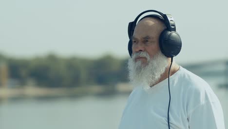 Pleasant-old-man-has-a-relax-listening-music-with-headphones