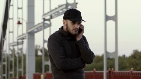 Man-talks-on-the-phone-at-the-bridge