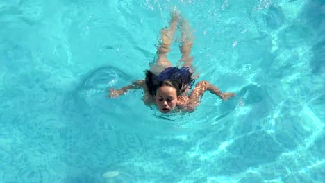 Young-woman-swim-in-the-swimming-pool,-aerial-trekking