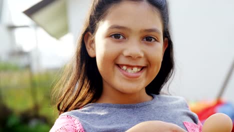 Happy-girl-holding-egg-and-spoon-in-backyard-4k