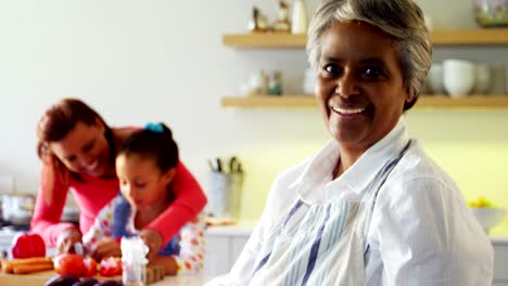 Smiling-grandmother-holding-recipe-book-in-kitchen-4k