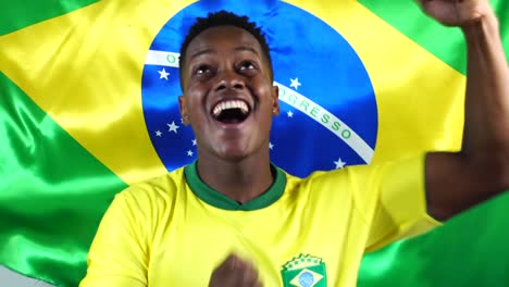 Joven-brasileño-negro-a-hombre-celebrando-con-la-bandera-de-Brasil