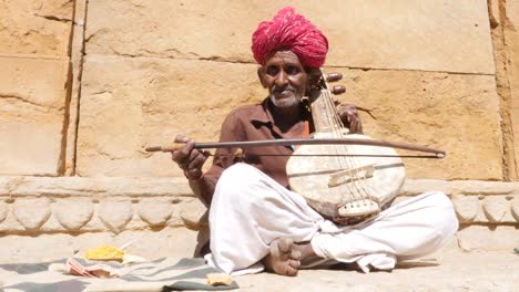 Indische-Senior-spielt-traditionelle-Musikinstrument-in-Jaisalmer-Fort,-Rajasthan,-Indien