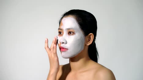 Young-woman-clay-face-mask-peeling-natural-with-purifying-mask-on-her-face-on-white-background