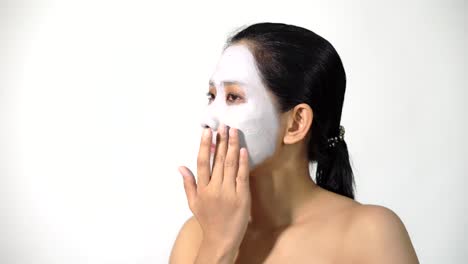 Young-woman-clay-face-mask-peeling-natural-with-purifying-mask-on-her-face-on-white-background