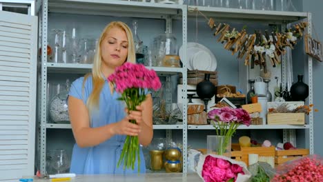 Professional-florist-holding-bouquet-of-pink-turkish-carnations-at-studio
