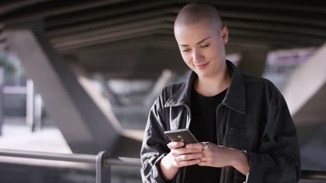 Modern-Girl-with-buzz-cut-typing-a-message-on-smartphone