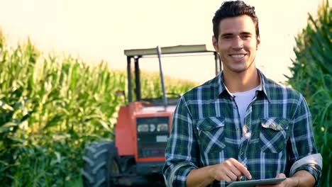 Porträt-eines-glücklichen-jungen-Landwirts-mit-frischem-Gemüse-in-einen-Korb.-Hintergrund-ein-Traktor-und-Natur-Konzept-biologischen,-Bio-Produkte,-Bio-Ökologie,-um-selbst-in-die-Hand,-Vegetarier,-Salate-gesund-gewachsen