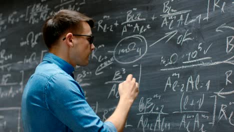 Brilliant-Young-Academic-Finishes-Writing-Big-and-Complex-Mathematical-Formula/-Equation-on-the-Blackboard.