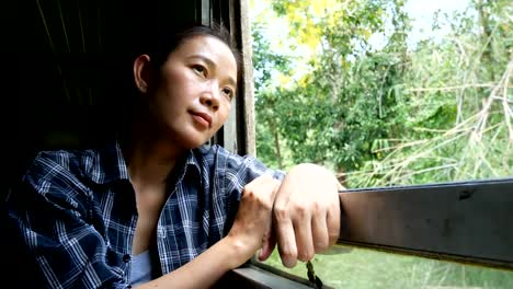 4-viajes-de-mujer-asiática-de-K.-en-tren-mirando-por-la-ventana-del-tren-en-ferrocarril-tren-Inicio-en-Bangkok-ir-a-Kanchanaburi-en-Tailandia.-disfrutar-de-transporte-por-tren-vintage