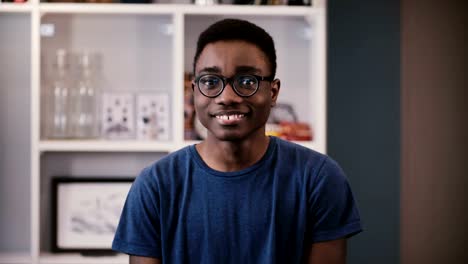 Happy-African-American-businessman-looks-at-camera.-Handsome-black-young-guy-in-glasses-smiling-joyfully.-Student.-4K