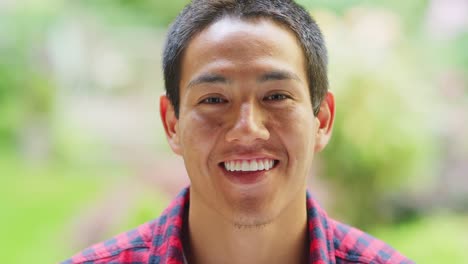 A-young-man-smiles-in-front-of-a-camera,-portrait