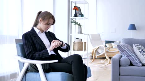 Mujer-usando-Smartwatch-sentado-en-el-sofá